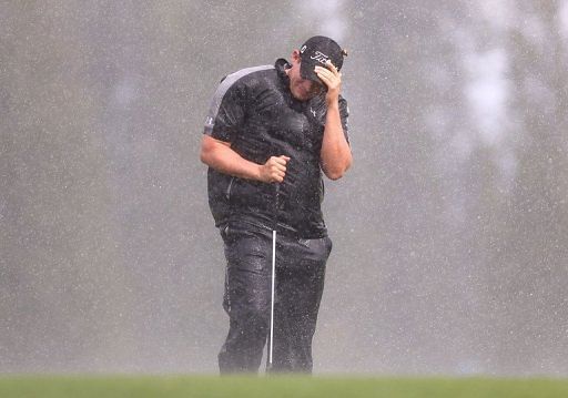 Scott Stallings shields himself from the wind and rain at the Plantation Course in Kapalua, Hawaii, on January 4, 2013