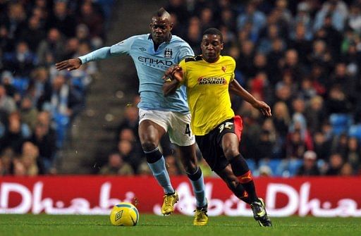 Manchester City&#039;s Mario Balotelli (L) clashes with Watford&#039;s Geoffrey Mujangi Bia in Manchester on January 5, 2013