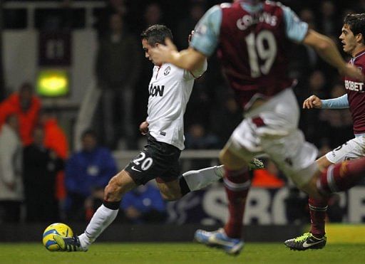 Robin Van Persie (L) shoots to score his late equalizing goal in East London on January 5, 2013