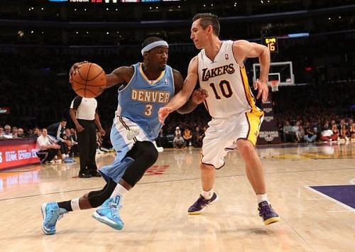 Ty Lawson (L) of the Denver Nuggets drives past Los Angeles Lakers' Steve Nash during their game on January 6, 2013