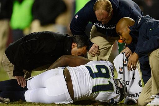 Chris Clemons of the Seattle Seahawks receives attention after being injured during their game on January 6, 2013