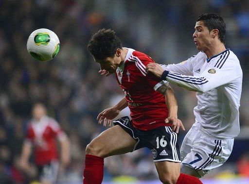 Real Madrid&#039;s Portuguese forward Cristiano Ronaldo (R) vies with Celta&#039;s defender Carlos Bellvis on January 9, 2013