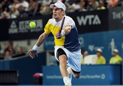 Jarkko Nieminen returns a shot against Bernard Tomic during their quarter-final match in Sydney on January 10, 2013