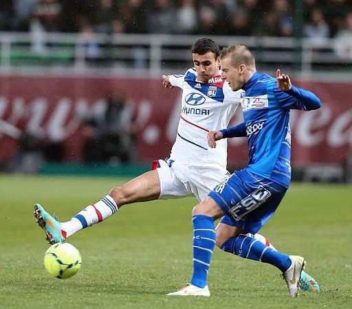 Troyes&#039; Stephane Darbion (R) clashes with Lyon&#039;s Maxime Gonalons on January 12, 2013 at the Aube Stadium in Troyes