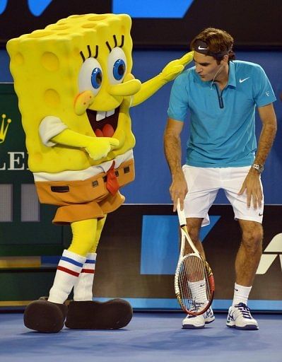 Roger Federer warms up with cartoon character Sponge Bob during a Kids Day exhibition match on January 12, 2013