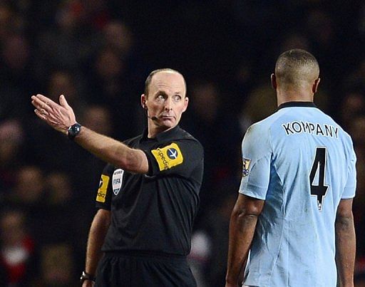 City&#039;s Vincent Kompany (R) is shown a red card by referee Mike Dean (L) at the Emirates Stadium on January 13, 2013