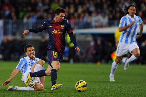Barcelona&#039;s Lionel Messi (C) vies for the ball with Malaga&#039;s Ignacio Camacho (L) on January 13, 2013 at Rosaleda stadium