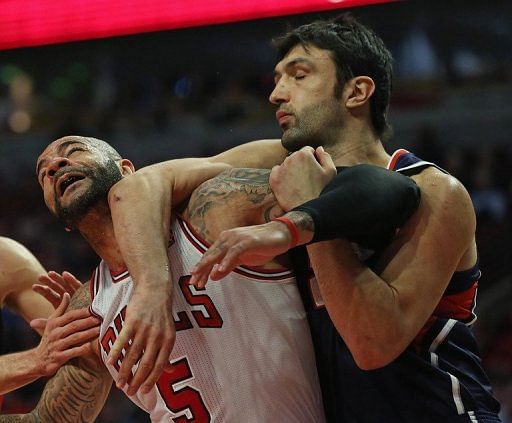 Zaza Pachulia (R) of the Atlanta Hawks gets to grips with Carlos Boozer of the Chicago Bulls on January 14, 2013