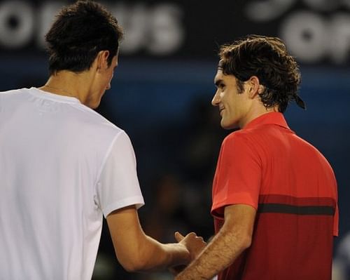 Roger Federer (R) shakes hands with Bernard Tomic after their fourth-round match on January 22, 2012