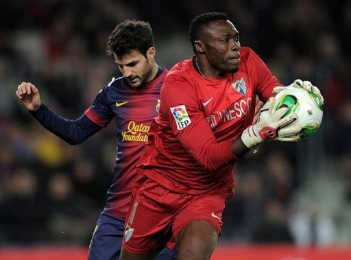 Malaga&#039;s goalkeeper Carlos Kameni vies with Barcelona&#039;s Cesc Fabregas in Barcelona on January 16, 2013