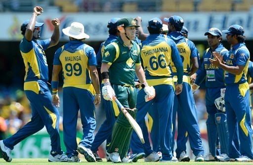 Australia's David Warner (C) is dismissed by Sri Lanka's Angelo Mathews in Brisbane on January 18, 2013