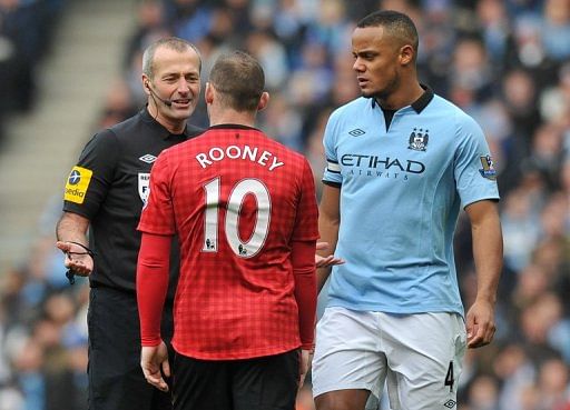 Vincent Kompany and Wayne Rooney talk with referee Martin Atkinson during the game at the Etihad on December 9, 2012