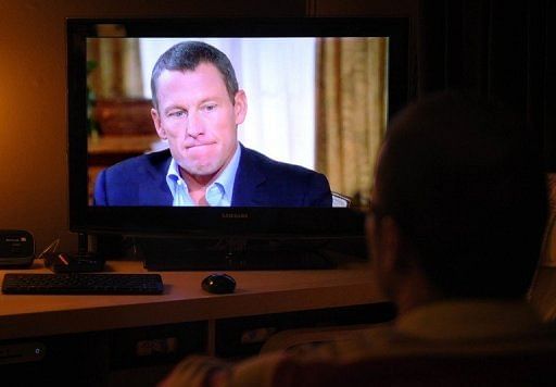 A man watches a TV showing disgraced cycling star Lance Armstrong being interviewed by Oprah Winfrey on January 17, 2013