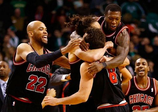 Marco Belinelli (R bottom) is swamped by his Chicago Bulls teammates after his turnaround jump shot on January 18, 2013