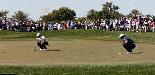 Tiger Woods (right) and Rory McIlroy line up putts in the Abu Dhabi Golf Championship on January 18, 2013