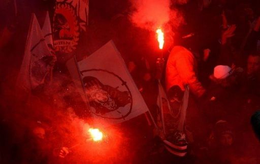 Hooligans hold flares during a Bundesliga football match in the German city of Leverkusen on January 19, 2013