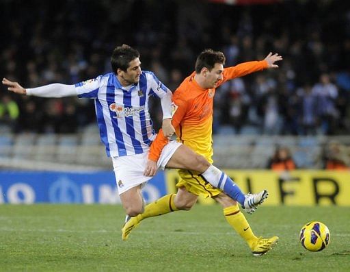 Barcelona&#039;s Lionel Messi (R) clashes with Real Sociedad&#039;s Markel Bergara in San Sebastian on January 19, 2013