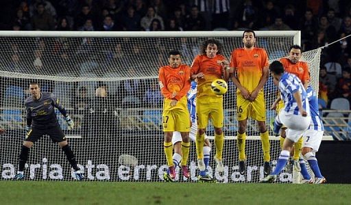 Real Sociedad&#039;s midfielder Gonzalo Castro (2nd R) shoots against Barcelona&#039;s defence on January 19, 2013