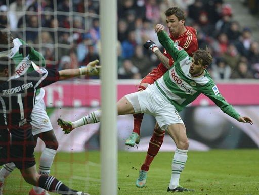 Bayern Munich&#039;s Mario Mandzukic (L) shoots against Fuerth&#039;s Christopher Noethe (R) in Munich on January 19, 2013
