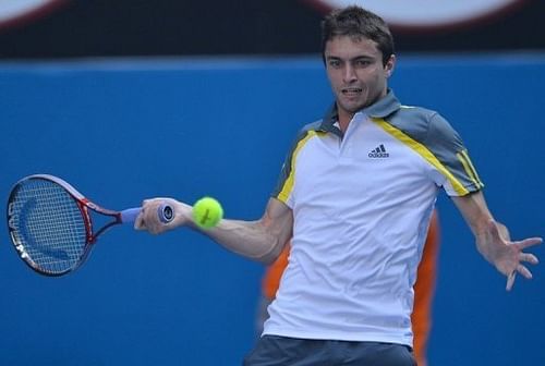 Gilles Simon hits a return against Andy Murray during their Australian Open match in Melbourne on January 21, 2013