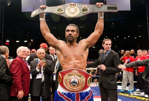 David Haye (C) raises his belt trophy in east London on July 14, 2012