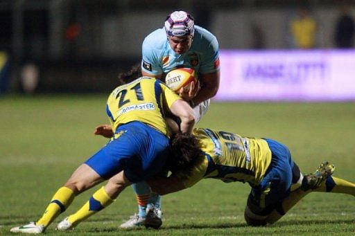Perpignan&#039;s Dan Leo (C) is tackled by Clermont&#039;s David Skrela on January 25, 2013 in Perpignan