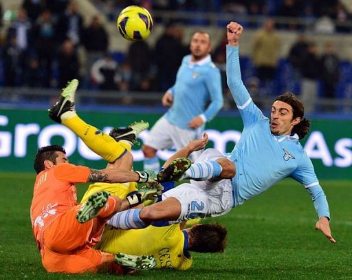Lazio&#039;s Giuseppe Biava (R) fights for the ball with Chievo Christian Puggioni (L) and Bostjan Cesar on January 26, 2013