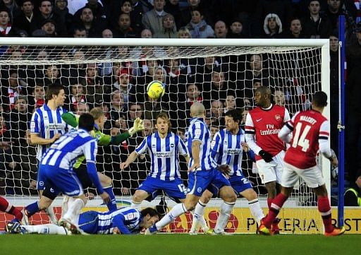 Arsenal&#039;s Theo Walcott (R) scores their third goal during their 3-2 win over Brighton &amp; Hove Albion on January 26, 2013