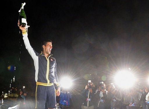 Serbia&#039;s Novak Djokovic for photographers during a presentation ceremony in Melbourne on January 27, 2013