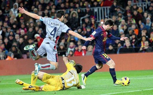 Barcelona&#039;s Lionel Messi (R) vies with Osasuna&#039;s Miguel Flano Bezunartea (L) in Barcelona on January 27, 2013
