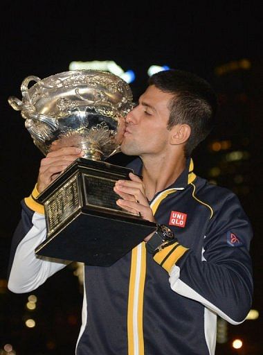 Serbia&#039;s Novak Djokovic poses with the trophy in Melbourne early January 28, 2013