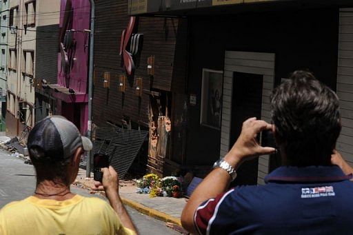Passersby take snapshots of the facade of the Kiss nightclub on January 28, 2013 in Santa Maria, southern Brazil