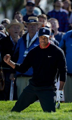 Tiger Woods clenches his fist after hitting out of the 11th green bunker en route to victory on January 28, 2013