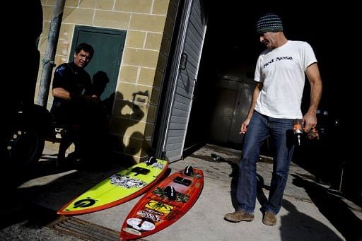 Hawaiian surfer Garrett McNamara fixes his surfboards before taking part in a surf session in Nazare on January 29, 2013