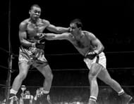 Rocky Marciano's eyes glint confidently after he drives a tr