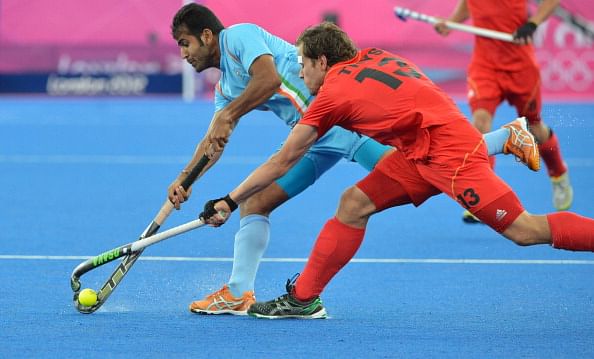 Tushar Khandekar of India dribbles past