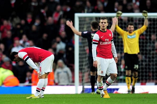 LONDON, ENGLAND - FEBRUARY 16:  Dejected Arsenal players Mikel Arteta (L) and Jack Wilshere (R) look on as Blackburn players celebrate their team&#039;s 1-0 victory during the FA Cup with Budweiser fifth round match between Arsenal and Blackburn Rovers