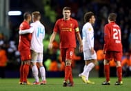 LIVERPOOL, ENGLAND - FEBRUARY 21: A dejected Steven Gerrard of Liverpool walks off the pitch following his team's exit from the competition during the UEFA Europa League round of 32 second leg match between Liverpool FC and FC Zenit St Petersburg