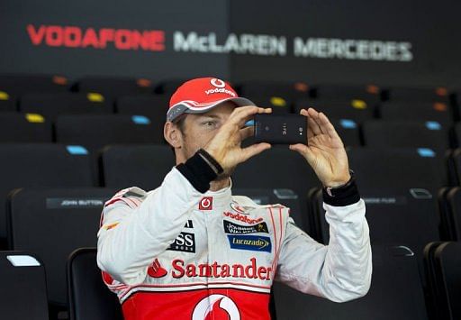 Jenson Button takes a picture of the new McLaren Mercedes MP4-28 in Woking, southern England, on January 31, 2013
