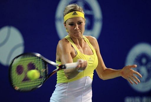 Kirilenko returns a shot to Sorana Cirstea of Romania during their  semi-final match in Pattaya on February 2, 2013
