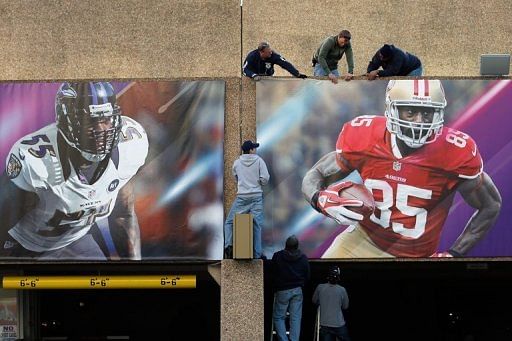 Workers install signs at the Superdome ahead of the Super Bowl 47 in New Orleans, Louisiana on January 31, 2013