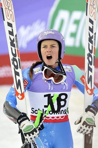 Slovenia's Tina Maze watches as Lindsey Vonn falls at the World Ski Championships in Schladming on February 5, 2013