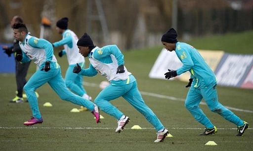 Brazil's Ronaldinho (R) warms up with teammates during a training session in Edgware, London, on February 5, 2013