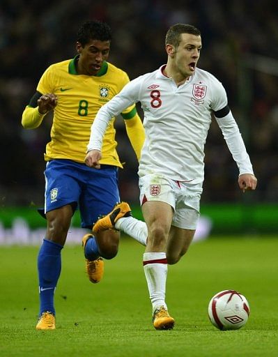 England's Jack Wilshere tries to shake off Brazil midfielder Paulinho during the friendly at Wembley on February 6, 2013