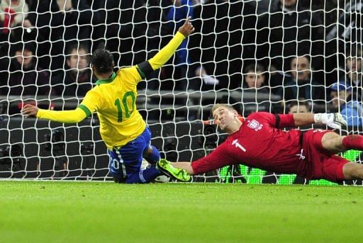 Joe Hart (R) saves Ronaldinho's attempts to follow up after Hart saved the Brazilian's penalty, on February 6, 2013