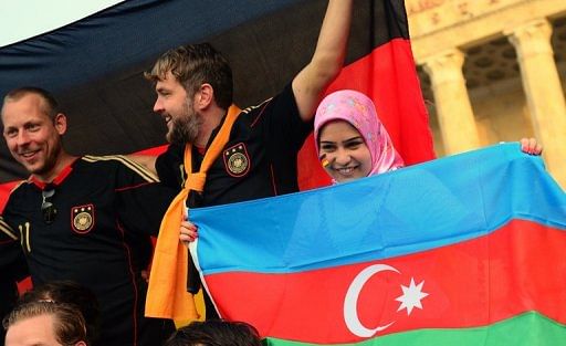 Fans wave the Azerbaijan and German flags before a football Euro 2012 qualifier on June 7, 2011 in Baku, Azerbaijan