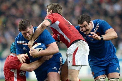 France&#039;s prop Vincent Debaty (L) runs with a ball past Wale&#039;s scrum half Mike Phillips (C) on February 9, 2013