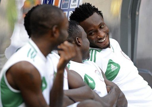 John Obi Mikel (R) shares a joke with his Nigerian team-mates as they prepare for a training session on February 9, 2013