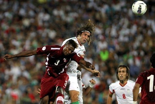 Iran&#039;s Hadi Aghily (centre) and Qatar&#039;s Mohammad Kasola at the Azadi Stadium in Tehran, Iran on June 12, 2012