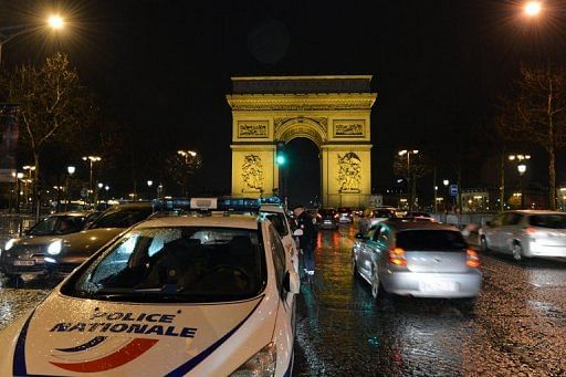 Police vehicles park in front of the Arc de Triomphe in Paris on December 31, 2012